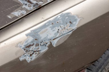 Boyası çıkarılmış bir araba parçası. Mekanik bir yöntem kullanarak yüzeyden boya öğütüyor