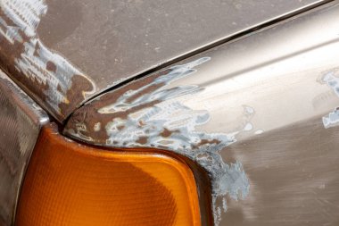 Arabanın boyası, kaputu ve kanadı alınmış bir parçası. Mekanik bir yöntem kullanarak yüzeyden boya öğütüyor