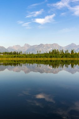 Dağ gölü yansımalı sakin su, ormanla çevrili, Kodar dağ sırası.