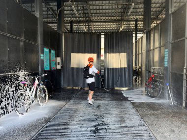 Otomobil yıkamada bir adam bisikleti köpükle kaplıyor. Bishkek, Kırgızistan - 25 SEP 2025