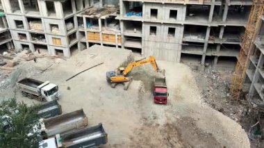 Hyundai kazıcısı bir apartmanın inşaat alanındaki bir kamyona toprak yüklüyor. İnşaat işi. Bishkek, Kırgızistan - 28 SEP 2025
