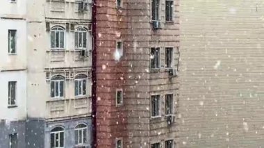 Bir apartmanın arka planına kar taneleri gibi yağar. Kış havası, ilk kar..