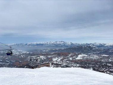 Özbekistan 'daki Amirsoy kayak merkezinde kayak pisti ve teleferik kamaraları. Kış manzarası, dinlenme yeri