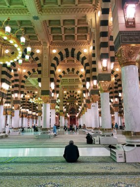 Tanımlanamayan Müslüman, El-Nabawi, Suudi Arabistan 'daki Mescid-i Haram' da bir sonraki duanın başlamasını beklerken oturuyor..