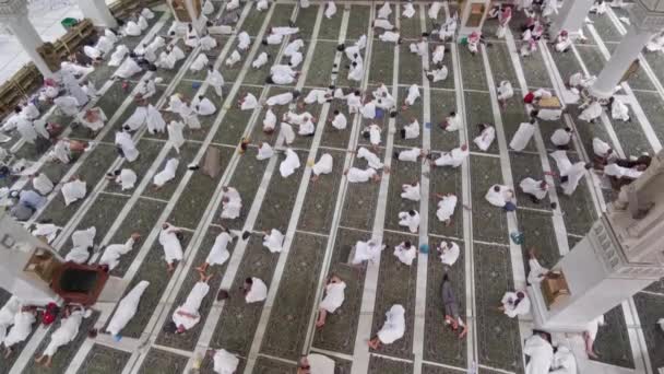 サウジアラビアのマッカにあるアル ハラム モスクの中に ハイラム の服の巡礼者の姿を見る アラム の服は 無数の白い服で構成されています — ストック動画