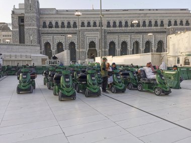 MECCA, SAUDI ARABIA KINGDOM (KSA) - 12 Haziran 2023: Suudi Arabistan 'ın Makkah kentindeki Al Haram Camii' nın dışındaki seyyahlar için çevre dostu pille çalışan golf arabaları.