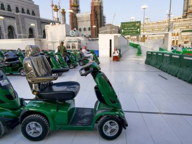 MECCA, SAUDI ARABIA KINGDOM (KSA) - 12 Haziran 2023: Suudi Arabistan 'ın Makkah kentindeki Al Haram Camii' nın dışındaki seyyahlar için çevre dostu pille çalışan golf arabaları.