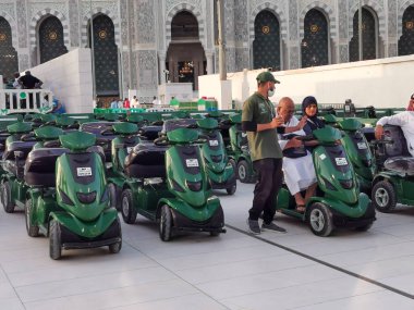 MECCA, SAUDI ARABIA KINGDOM (KSA) - 12 Haziran 2023: Suudi Arabistan 'ın Makkah kentindeki Al Haram Camii' nın dışındaki seyyahlar için çevre dostu pille çalışan golf arabaları.