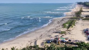 Rüzgarlı bir günde kumlu plajlı panoramik deniz manzarası.