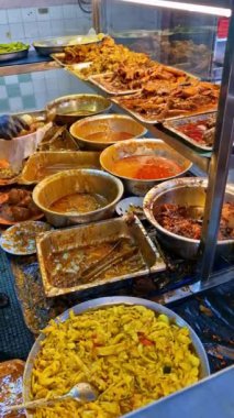 Malezya 'nın Penang kentinde kimliği belirsiz işçilere ait' nasi kandar 'ya da' kandar 'pilavı hazırlıyor. 'Nasi kandar' Penang 'lı Müslüman tüccarlardan gelen popüler bir baharatlı yemektir.