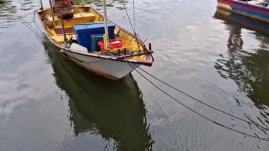 Sakin bir nehir ağzına kenetlenmiş ahşap ve fiberglas malzemeden yapılmış basit bir teknenin statik çekimi. Bu balıkçı tekneleri yerel halk tarafından kullanılıyordu..