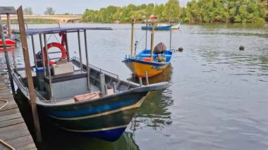 Sakin bir nehir ağzına kenetlenmiş ahşap ve fiberglas malzemeden yapılmış basit geleneksel teknelerin statik çekimi. Bu balıkçı tekneleri yerel halk tarafından kullanılıyordu..