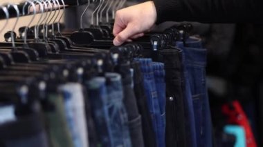 Kıyafet seçen yakışıklı müşterilere yaklaş. Kotları tutan adamın eli.