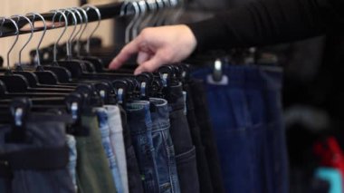 Kıyafet seçen yakışıklı müşterilere yaklaş. Kotları tutan adamın eli.