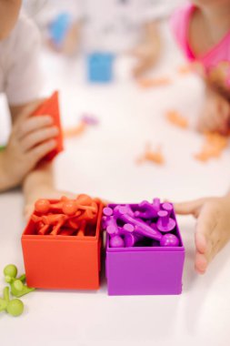 Oyuncak maymunla oynayan yakın çekim çocukları. Farklı renkte oyuncaklar. Küçük çocuklar için eğitim.