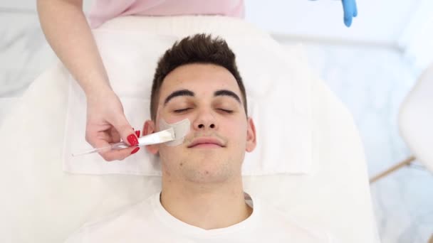 Młody Brunetka Włosów Mężczyzna Podczas Zabiegu Obierania Klinice Kosmetycznej Przystojny — Wideo stockowe