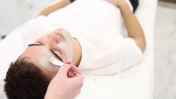 Jonge Brunette Haarman Tijdens Peeling Behandeling Schoonheidskliniek Knappe Man Kosmetologie — Stockvideo