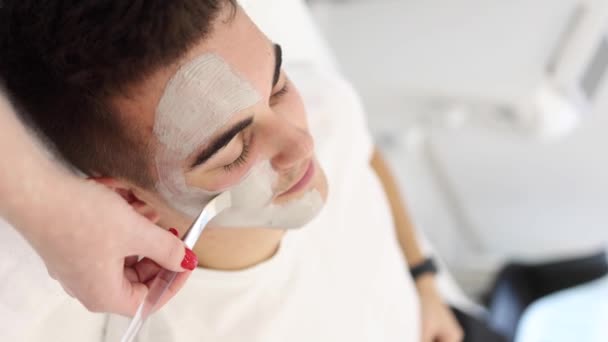 Kosmetolog Menerapkan Masker Tanah Liat Pada Pria Wajah Spa Salon — Stok Video