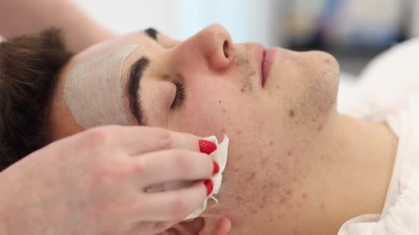 Kosmetolog Tvättar Lera Masken Med Våt Servett Från Mans Ansikte — Stockvideo