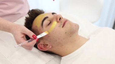 Güzellik stüdyosunda altın maskeli yakışıklı bir adam. Spa salonundaki en iyi erkek manzarası..