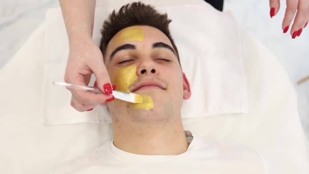 Hombre Guapo Con Máscara Dorada Estudio Belleza Hombre Salón Spa — Vídeos de Stock