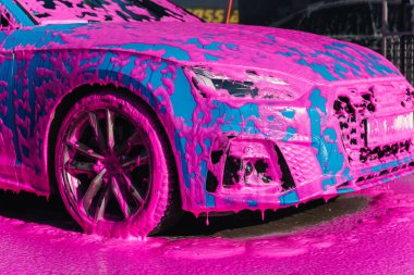 Luxury sport blue car on self servise car washing. Pink foam on auto.