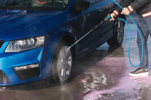 Process of cleaning car with a jet sprayer. Self service car washing.