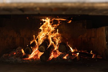 Fire place outdoor. Firewood. Yeallow fire and red hot coals.