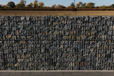 The crushed stone is fixed in the mesh. A fence made of natural stone, crushed stone, granite