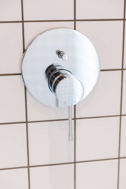 Silver glossy water switch in the bathroom.