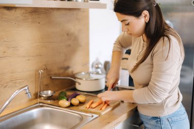 Young mom preparing food at home for her family. Caring woman prepares homemade food. High quality photo