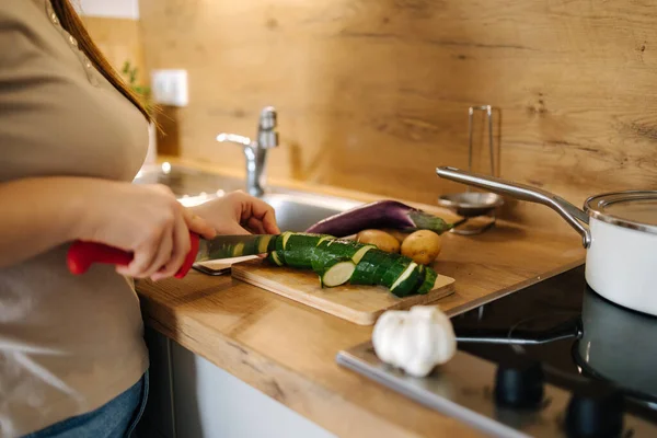 stock image Photo of a woman cutting zucchini on a wooden board. Home food concept . High quality photo