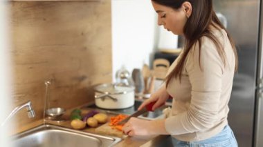 Genç anne ailesi için evde yemek hazırlıyor. Şefkatli kadın ev yemeği hazırlar. Yüksek kalite 4k görüntü