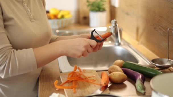 Samica Marchewki Użyciem Obieraczki Warzyw Zbliżenie Kobiecej Dłoni Kuchni Przygotowuję — Wideo stockowe