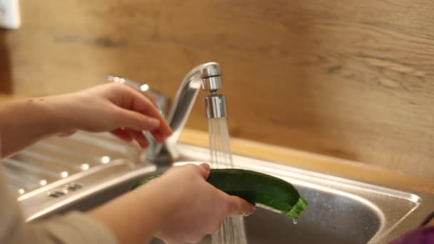 Großaufnahme Einer Frau Die Einen Wasserhahn Öffnet Und Eine Zucchini — Stockvideo