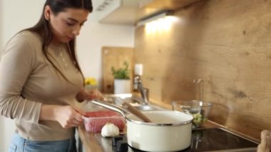 Evde yemek hazırlayan çekici bir kadın. Küçük bir mutfak manzarası. Yüksek kalite 4k görüntü