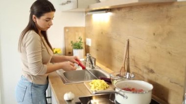 Çekici, genç bir kadın bıçak yıkıyor. Evde yemek hazırlayan bir kadın. Yüksek kalite 4k görüntü
