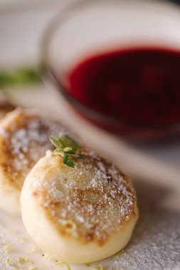 Kremalı börekler tabakta pudra şekeri ile süslenmiş. Cheesecake, taze reçel, ekşi krema ve nane. Yüksek kalite fotoğraf