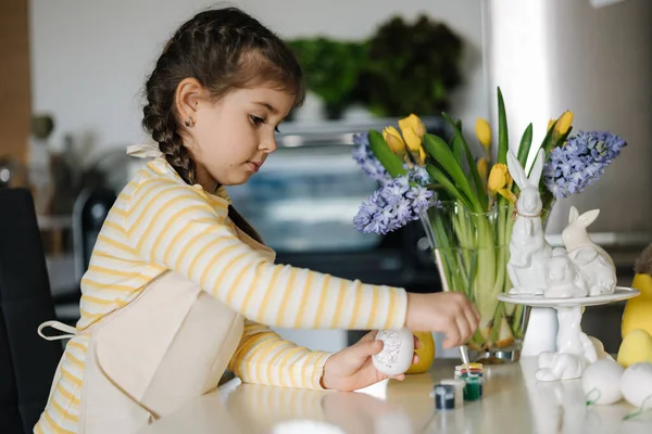 可爱的微笑女孩手里拿着画笔和鸡蛋 准备画画 厨房的复活节装饰 高质量的照片 — 图库照片