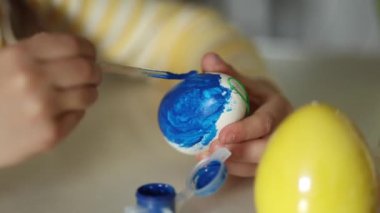 Mutfakta paskalya yumurtası yetiştiren küçük bir kızın makro fotoğrafı. Sarı ve mavi. Ukraynalı sembolik. Yüksek kalite 4k görüntü