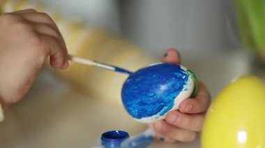 Mutfakta paskalya yumurtası yetiştiren küçük bir kızın makro fotoğrafı. Sarı ve mavi. Ukraynalı sembolik. Yüksek kalite 4k görüntü