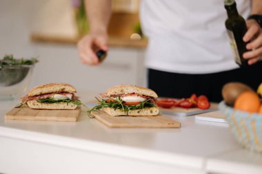 Adam klasik İtalyan bruschetta 'sına soğuk keten tohumu yağı döküyor. Vejetaryen sağlıklı yemek. Yüksek kalite fotoğraf