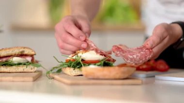 Adam bruschetta 'nın üstüne bir dilim İtalyan salamı koymuş. Sağlıklı ev yapımı yemek. Yüksek kalite 4k görüntü