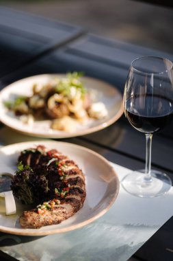 Fırında domuz filetosu ve yaz terasında bir tabak patates. Açık hava yemeği. Yüksek kalite fotoğraf