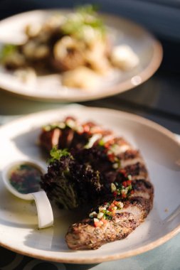 Fırında domuz filetosu ve yaz terasında bir tabak patates. Açık hava yemeği. Yüksek kalite fotoğraf