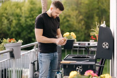 Adam ızgarada ateş yakmak için ateş briketleri kullanıyor. Terasta açık hava barbeküsü. Yüksek kalite fotoğraf