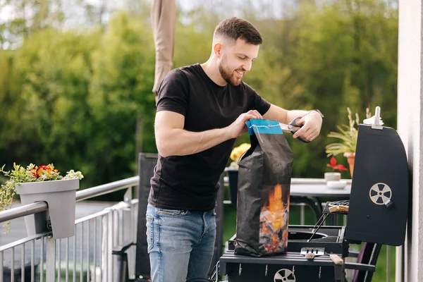 Man Opens Package Charcoal Grilling Preparing Barbecue Backyard High Quality — Stock Photo, Image
