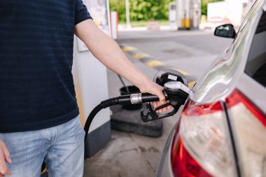 Benzin istasyonunda arabaya yakıt ikmali yapan adam. Yakıt istasyonunda benzinle benzin dolduran bir sürücünün yakın çekimi. Yüksek kalite fotoğraf