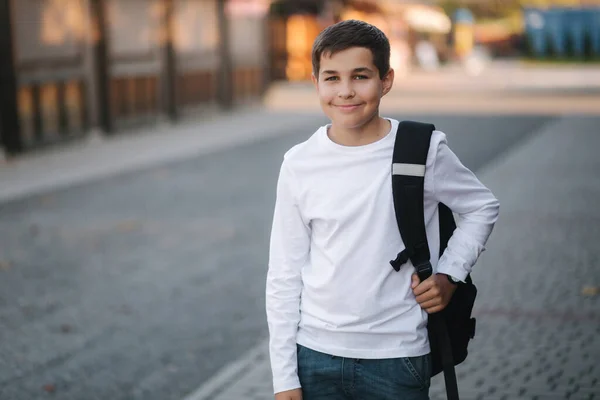 一个穿着白色运动衫 背着背包的快乐少年的画像 — 图库照片
