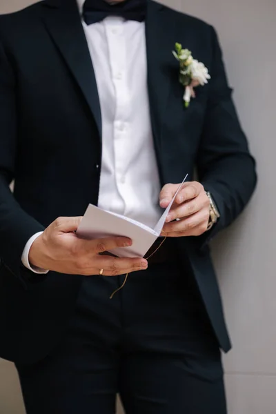 タイ弓とBoutonniereとスタイリッシュなダークブルーのスーツでエレガントな新郎の中間選択 結婚式の日 高品質の写真 — ストック写真